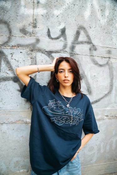 A navy T-shirt photographed on a model, before and after background removal with Sweepcut